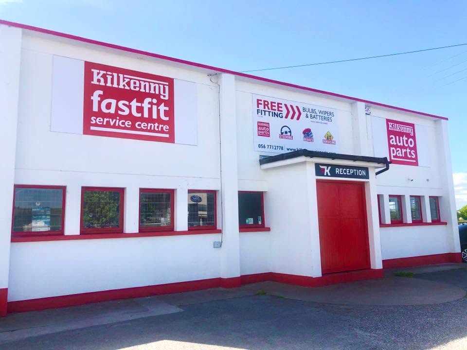 Fast Fit Kilkenny modern car repair workshop with mechanic working under a vehicle on a hydraulic lift